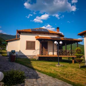 a house with a porch with a solar roof at Karyon Apartments in Kariófiton