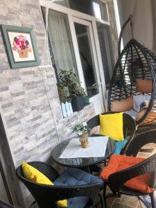 un patio con sillas y una mesa con almohadas amarillas en Dea Apartments, en Batumi