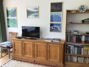 a television on a wooden cabinet in a living room at Komfortable Ferienwohnung mit herrlicher Aussicht in Sautens