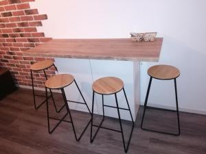 a table with two stools and a table with a counter at Le Temps d'une Pause in Bourgoin
