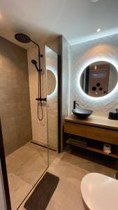 a bathroom with a shower with a sink and a mirror at Royal Green in Zandvoort