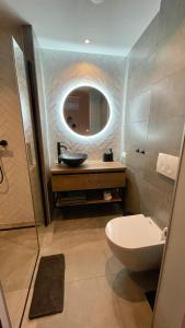 a bathroom with a sink and a toilet and a mirror at Royal Green in Zandvoort