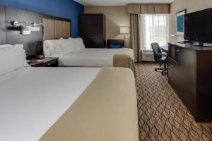 a hotel room with two beds and a flat screen tv at Holiday Inn Express Hunt Valley by IHG in Hunt Valley