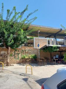 a brick building with a patio with tables and chairs at Cozy spot apt next to metro station . in Athens