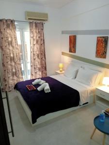 a bedroom with a large bed with two towels on it at Cozy spot apt next to metro station . in Athens