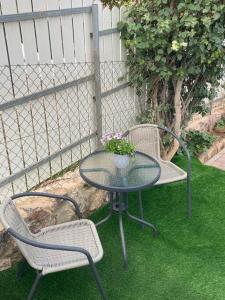 una mesa con 2 sillas y una mesa con una planta en יחידת נופש מדהימה ומעוצבת לנופש מושלם בערד en Arad