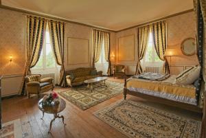 una camera con letto, divano e tavolo di Chateau du Hallay a Montaigu-Vendée