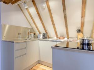 a kitchen with white cabinets and a counter top at The Loft At Brackley Town Hall in Brackley