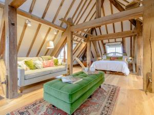 a living room with a green couch and a bed at The Loft At Brackley Town Hall in Brackley