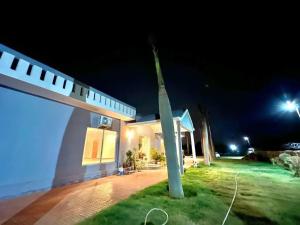 a pole in front of a house at night at Entrie 2 acre Farmhouse with Pool, 2 rooms & jacuzzi in both rooms in Gurgaon