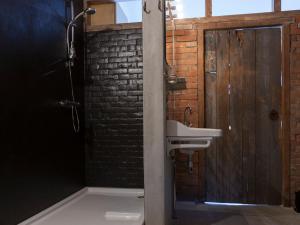 een badkamer met een wastafel naast een bakstenen muur bij Norgerbrink in Norg