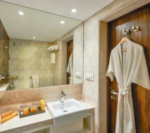 uma casa de banho com um lavatório e um espelho em Hotel Bawa Regency em Mumbai