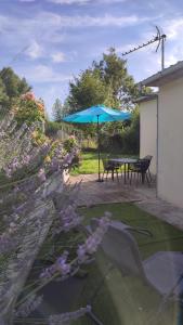 une terrasse avec une table et un parasol bleu dans l'établissement Le petit paradis, à Abbeville