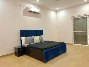a bedroom with a blue bed and a air conditioner at Entrie 2 acre Farmhouse with Pool, 2 rooms & jacuzzi in both rooms in Gurgaon