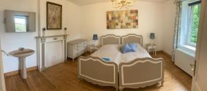 a bedroom with a bed and a sink in it at La Futaie de Chabrehez- maison typique ardennaise in Houffalize