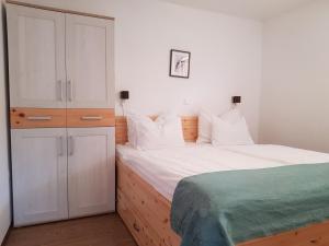 a bedroom with a large white bed and a cabinet at Apartments Katja in Kranjska Gora
