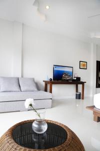 ein Wohnzimmer mit einem Tisch und einem Sofa in der Unterkunft The Langstan Suites in Nai Harn Beach