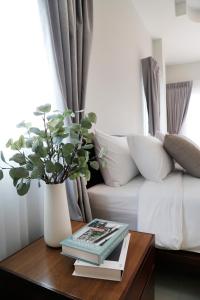 a coffee table with a book and a vase with a plant at The Langstan Suites in Nai Harn Beach