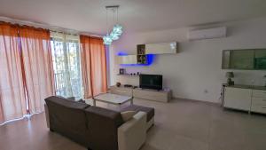 a living room with a couch and a tv at Paradise in Għajnsielem
