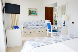 una camera con letto, sedia e divano di Hotel Caesar Residence & SPA a Lido di Camaiore