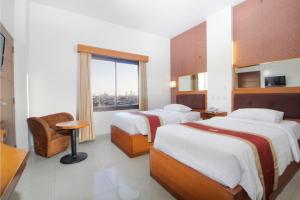 a hotel room with two beds and a window at Hotel Bisanta Bidakara Tunjungan in Surabaya
