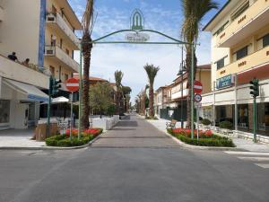 une rue vide dans une ville bordée de palmiers dans l'établissement Casetta Donatello, à Marina di Pietrasanta