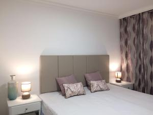 una camera con un letto bianco e 2 lampade di The SunSpot Apartment Playa del Inglés a Maspalomas