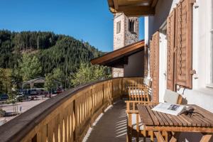 a balcony with a wooden table and chairs on a building at Ferienhaus Fingerhut in Eggen