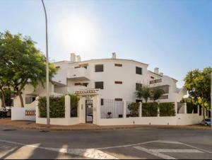 un bâtiment blanc au coin d'une rue dans l'établissement Pueblo Jardín charming Andalusian complex, à Benalmádena