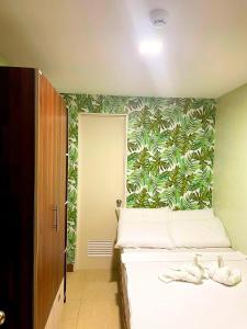 a bedroom with a bed with a tropical wallpaper at Mahayahay Lodge and Restaurant in Mactan