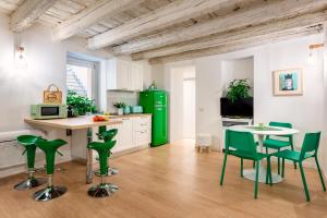 una cocina con electrodomésticos verdes, mesa y sillas en Casa Kawaii Midori en Cagliari