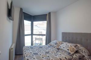 - une chambre avec un lit et une grande fenêtre dans l'établissement Apartament Bisaura de Ter, à Sant Quirze de Besora