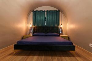 1 dormitorio con 1 cama con edredón azul y ventana en LOFT ATENEO, en Bari