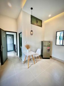 a kitchen with a white table and a refrigerator at MIDMOST HOUSE in Can Tho