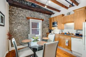 a kitchen with a table and chairs and a brick wall at Historic City Market - Loft Off Broughton Too in Savannah
