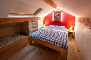 a small bedroom with a bed and red walls at Le Valtin Gite au calme in Le Valtin