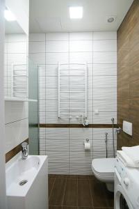 La salle de bains blanche est pourvue d'un lavabo et de toilettes. dans l'établissement Luxury Apartment near Rynok Square, à Lviv