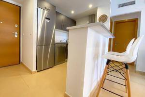 taburete blanco en una cocina con nevera en Superb luxurious groundfloor 1 bedroom app on Mar Menor golf resort en Torre-Pacheco