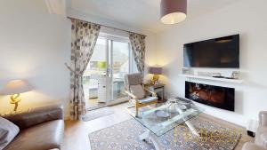 a living room with a couch and a fireplace at Min Y Don in Abersoch
