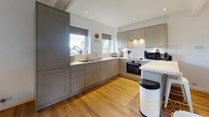 a large kitchen with white cabinets and a counter at Min Y Don in Abersoch