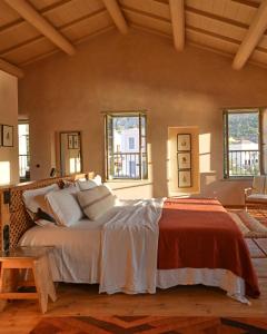 a bedroom with a large bed in a room with windows at Casa Mediterraneo Hotel in Meyisti