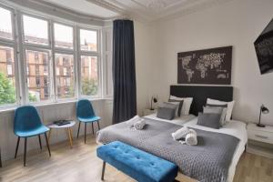 1 dormitorio con 1 cama grande y 2 sillas azules en Hotel Amager, en Copenhague