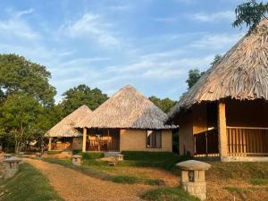 two huts with thatched roofs and a dirt road at Saffron Lake Yala in Tissamaharama