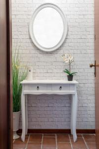 tocador blanco con espejo en la pared en Guest House Benny, en Reggio Emilia