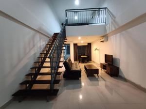 Una escalera en una casa con sofá y mesa en Double Storey PJ5 Soho Balcony Pool WIFI Netflix Field View, en Petaling Jaya