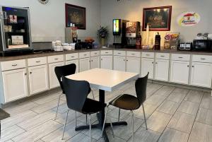 a kitchen with a table and chairs in it at Super 8 by Wyndham Bloomington, Indiana in Bloomington