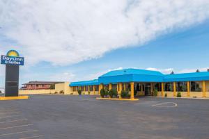 un edificio con un cartel en un estacionamiento en Days Inn & Suites by Wyndham Clovis, en Clovis