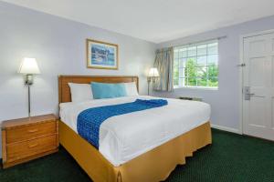 a bedroom with a large bed and a window at Travelodge by Wyndham Cape Cod Area in West Dennis