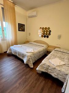 2 łóżka w pokoju z drewnianą podłogą w obiekcie Hotel degli Dei w mieście Pianoro