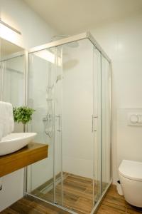La salle de bains est pourvue d'une douche en verre et d'un lavabo. dans l'établissement Villa Una, à Ohrid